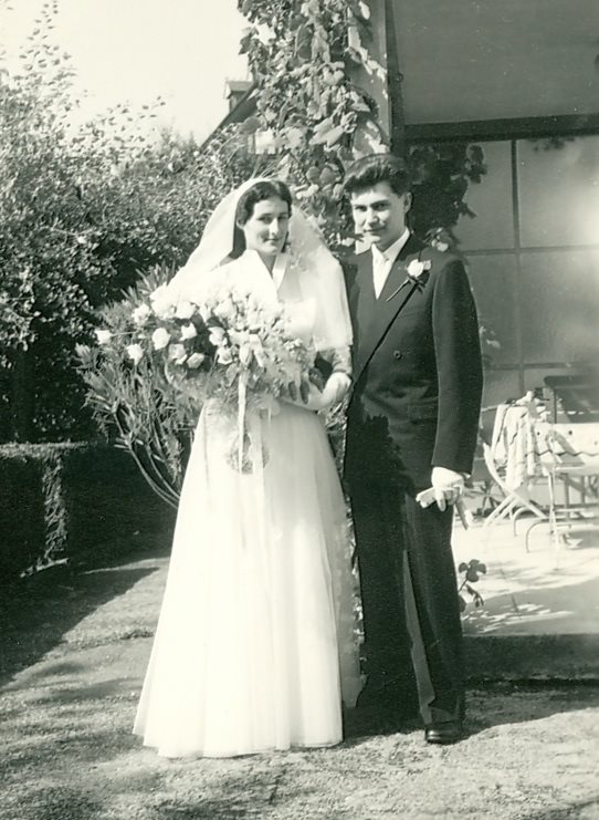 A bride and groom posing for a pictureAI-generated content may be incorrect.