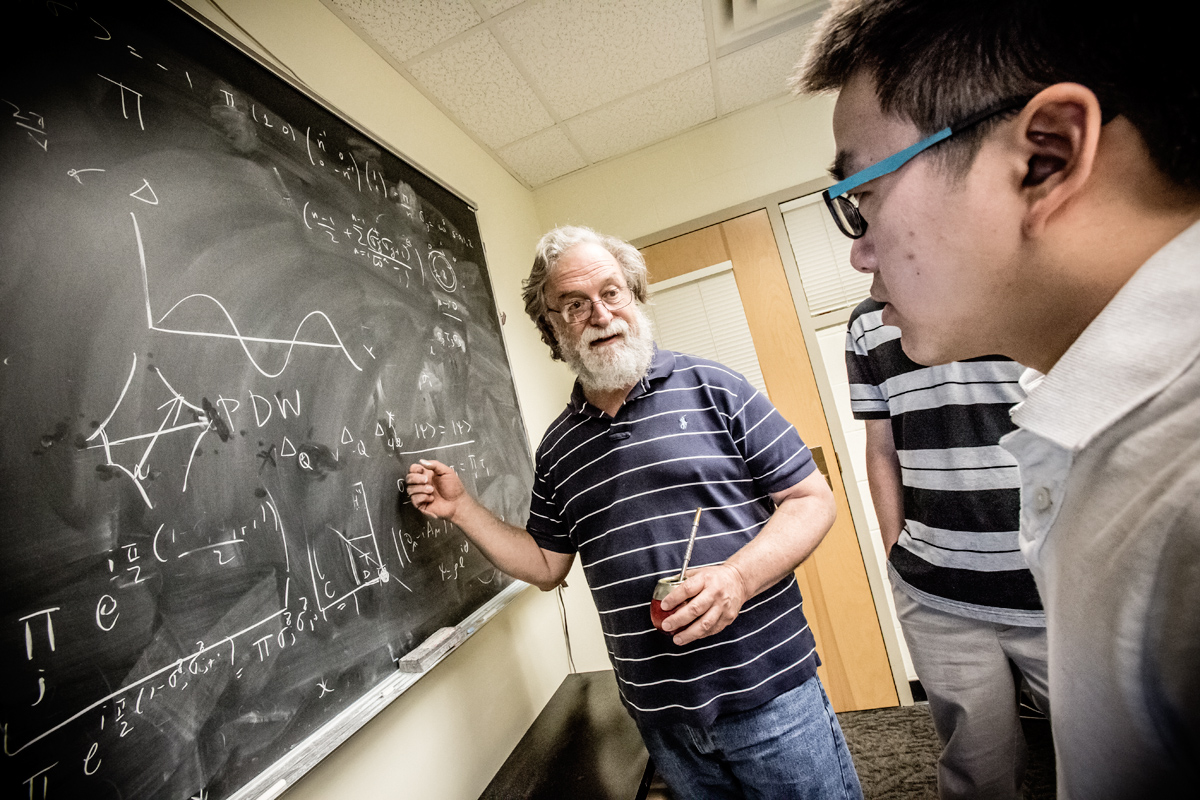 Eduardo Fradkin, a professor of physics and director of the Institute for Condensed Matter Theory (ICMT) at the University of Illinois at Urbana-Champaign, works with theoretical condensed matter grad students in his group, at the ICMT. Photo by L. Brian Stauffer, University of Illinois at Urbana-Champaign