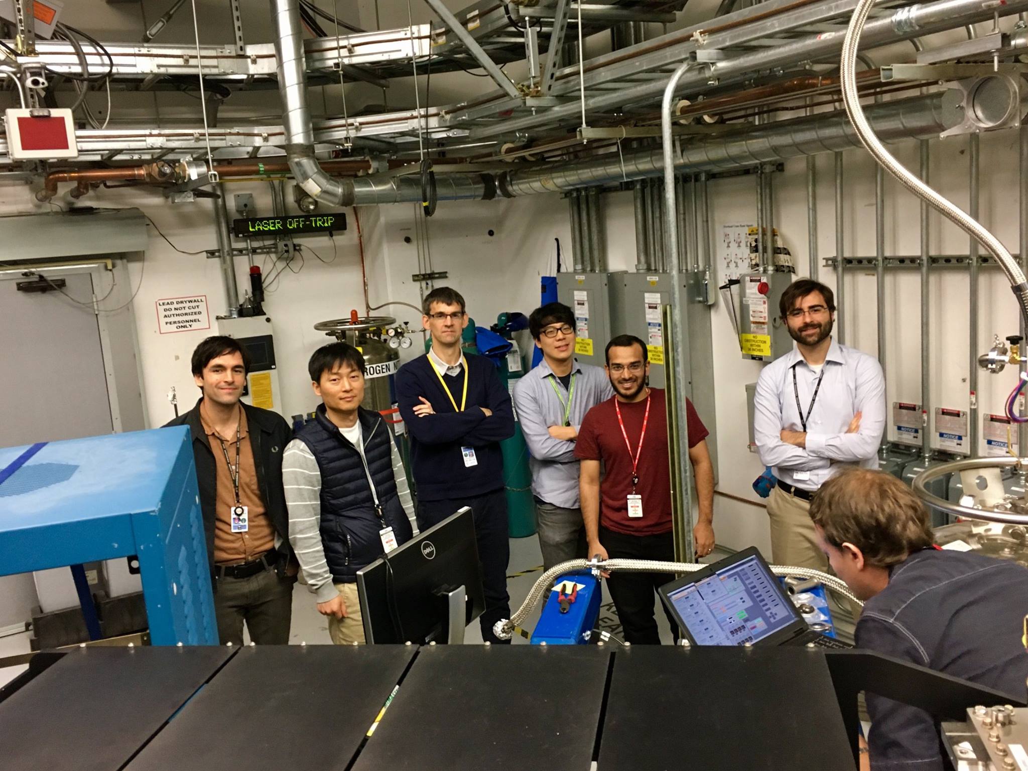 Professor Peter Abbamonte (middle, in navy sweater) and postdoctoral researcher Matteo Mitrano (right, in white dress shirt) pose with their team at the SLAC National Accelerator Laboratory in Menlo Park, California. The experimental team used a new investigative technique called time-resolved resonant soft x-ray scattering, to probe the striped charge order phase in a well-studied cuprate superconductor, with an unprecedented energy resolution, finding that superconductivity in cuprates may be mediated by charge-order fluctuations. This is the first time such an experiment has been done at an energy scale relevant to superconductivity. Source: SLAC