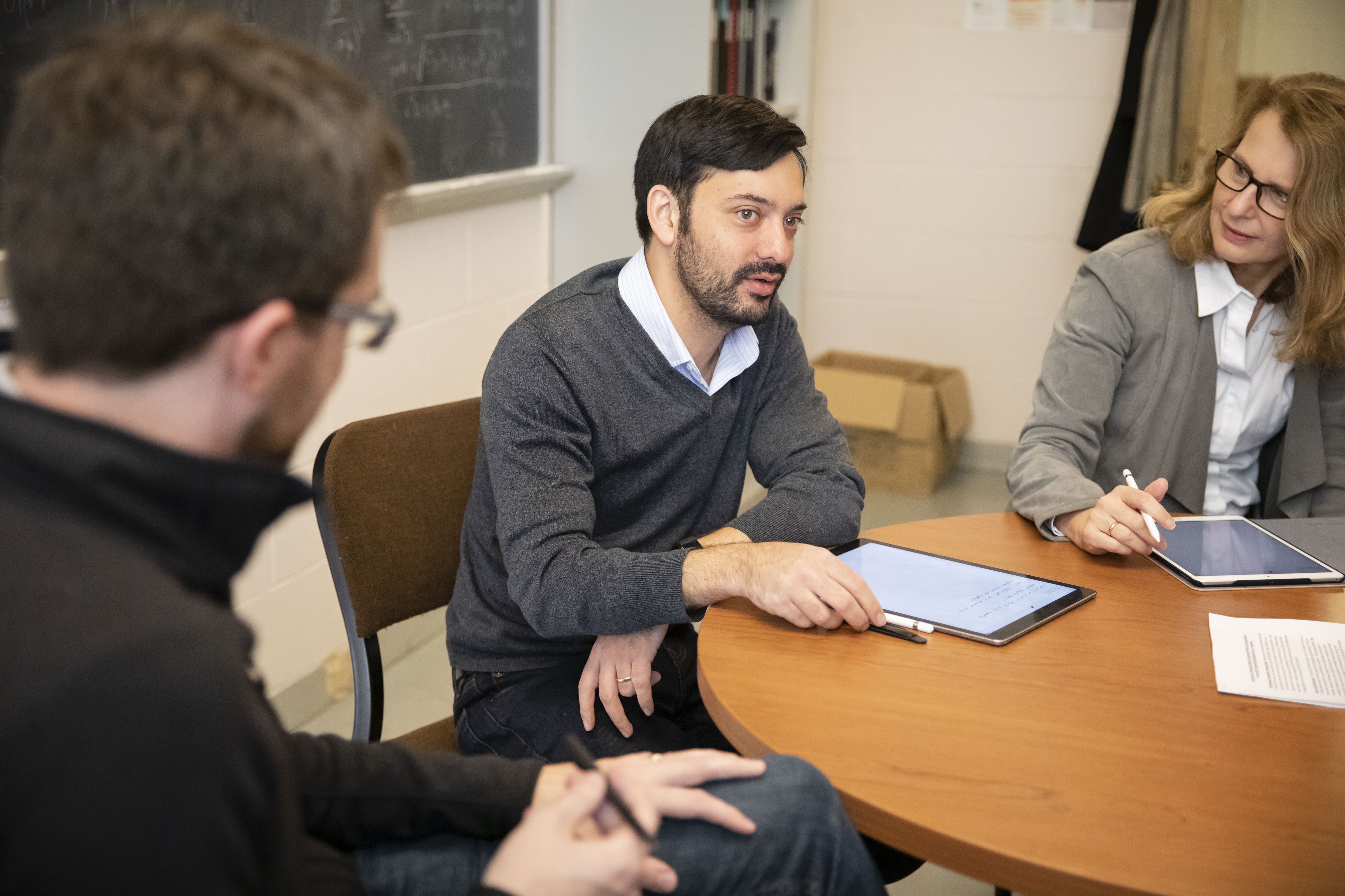 Professor Yonatan Kahn (center) talks with professors Patrick Draper (left) and Aida El-Khadra. Photo by L. Brian Stauffer, University of Illinois at Urbana-Champaign