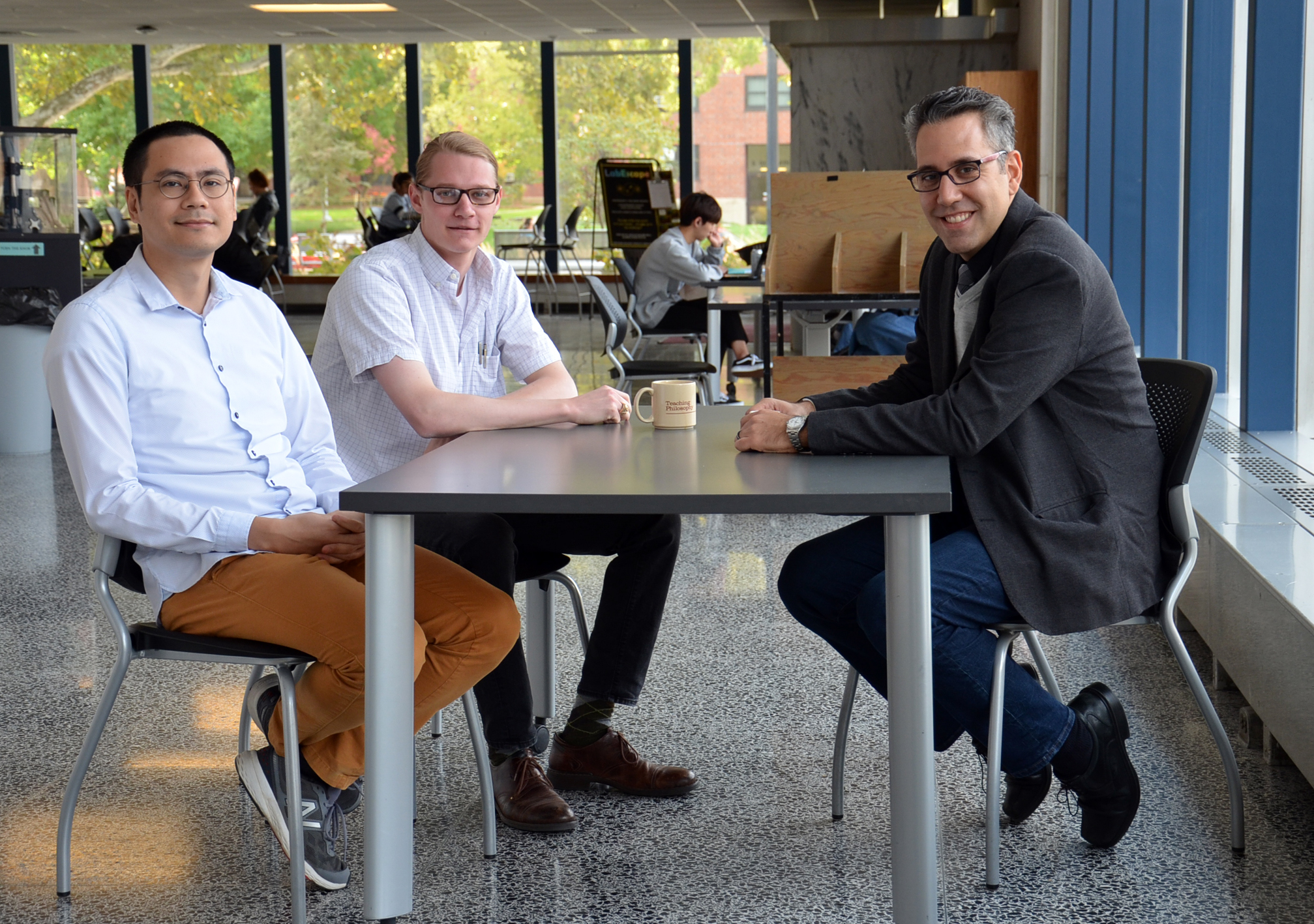 Professor Nico Yunes (right) meets with postdoc Hector Silva (left) and graduate student Scott Perkins.