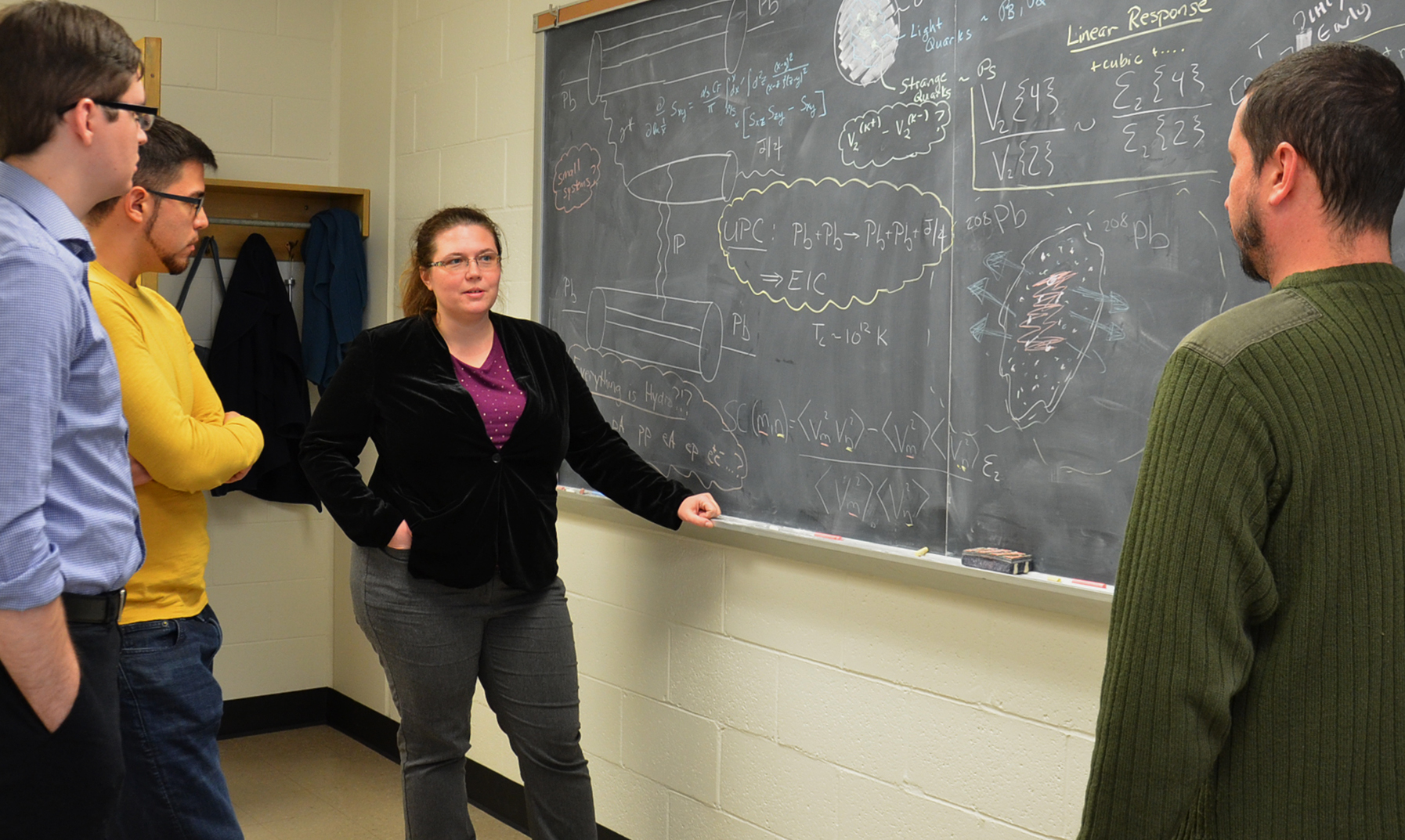 Professor Jaki Noronha-Hostler (center) works with postdoc Matthew Sievert (right) and graduate students Patrick Carzon (far left) and Travis Dore.