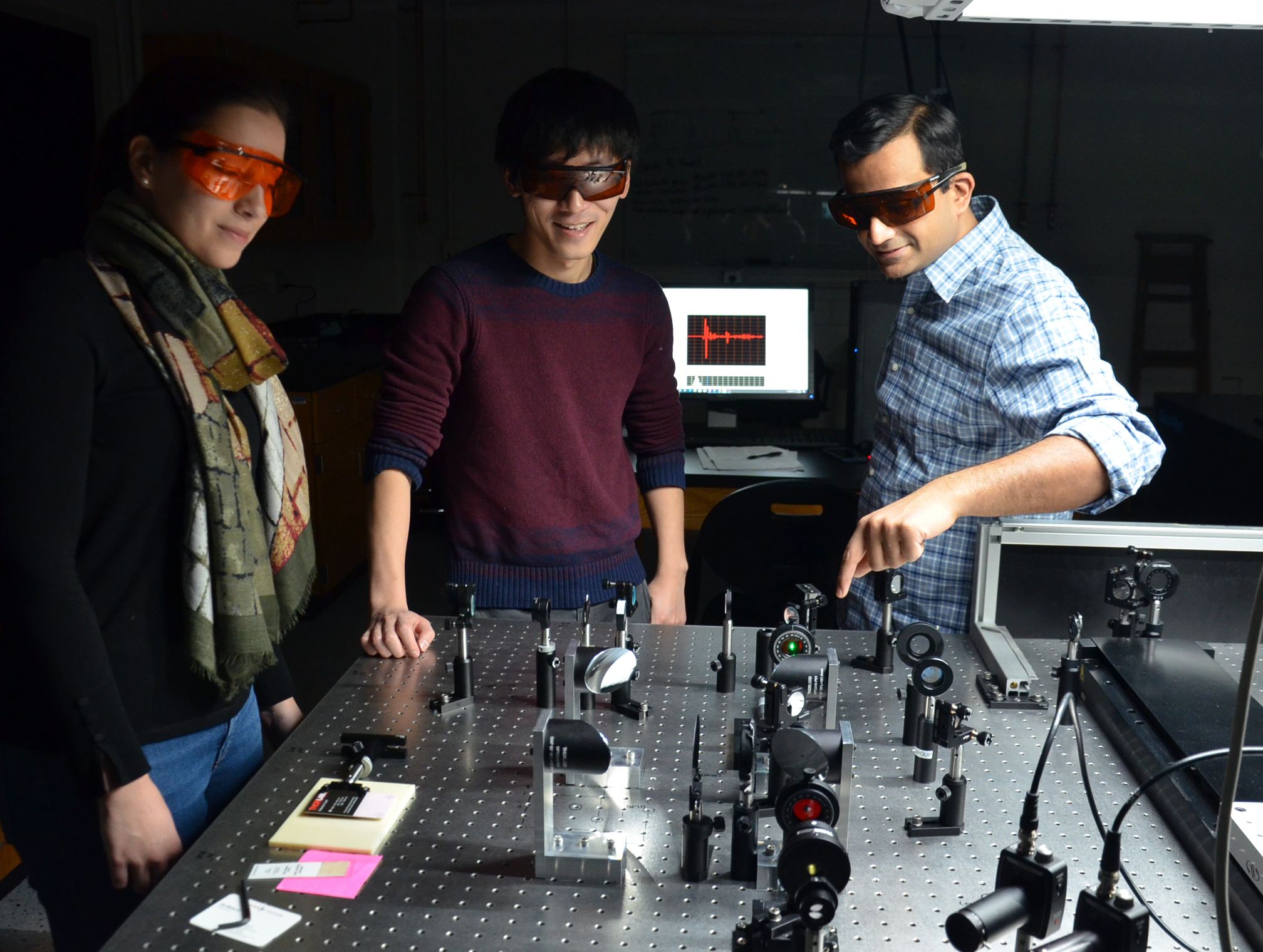 Professor Fahad Mahmood (right) works with graduate student Yinchuan Lu (center) and undergraduate student Andrea Perry (left) on generating and detecting THz radiation.