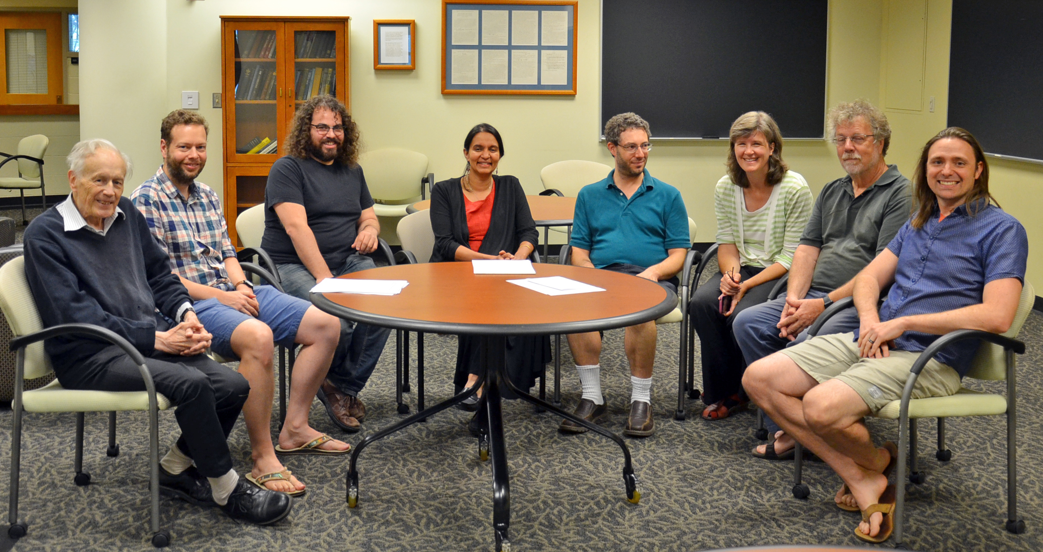 (L-R) Illinois Physics Professors Anthony Leggett, Lucas Wagner, Barry Bradlyn, Smitha Vishveshwara, Bryan Clark, Karin Dahmen, David Ceperley, and Taylor Hughes pause for a photo in the common room of the Institute for Condensed Matter Theory (ICMT) in Urbana. The Moore Foundation grant will support critical research projects involving all ICMT members. Photo by Siv Schwink for Illinois Physics