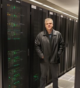 Illinois Physics Professor Mark Neubauer stands in the Illinois Campus Cluster (ICC) at the U of I Advanced Computation Building on the Urbana campus. Neubauer is the principal investigator for the Midwest Tier-2 Computing Center, which uses the ICC to process LHC data and to run numerical simulations in collaboration with the National Center for Supercomputing Applications.