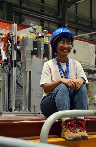 Illinois Physics undergraduate student Farah Mohammed Rafee poses in front of the ZDC/RPD setup at the Large Hadron Collider at CERN.