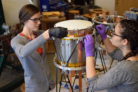 Illinois Physics graduate student Elle Shaw assembles a SPIDER-2 receiver in 2018 with then-Illinois Physics undergraduate researcher&nbsp;Kaliro&euml; Pappas, in the Filippini lab at Loomis Laboratory of Physics. The<a href="/news/high-bay"> ceiling of the fourth-floor laboratory has since been cut out and a high-bay created</a> for this project, with financial support from the department and from donors contributing to the department's Physics Priority Fund.