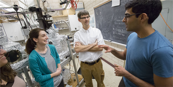 A photo of Peter Abbamonte and two of his graduate students in his lab.