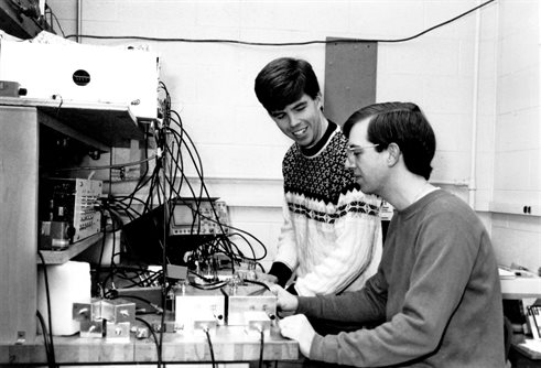 Graduate students Sean E. Barrett and Joe A. Martindale, students of Charles P. Slichter, use a nuclear magnetic resonance apparatus to study high-temperature superconductivity.